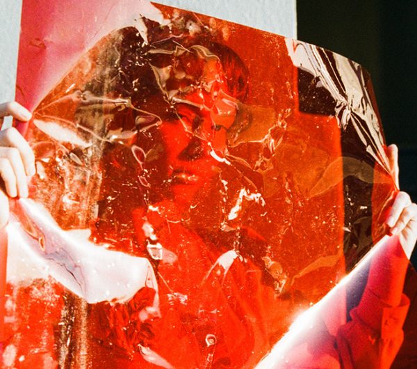Female hiding behind a transparent red film