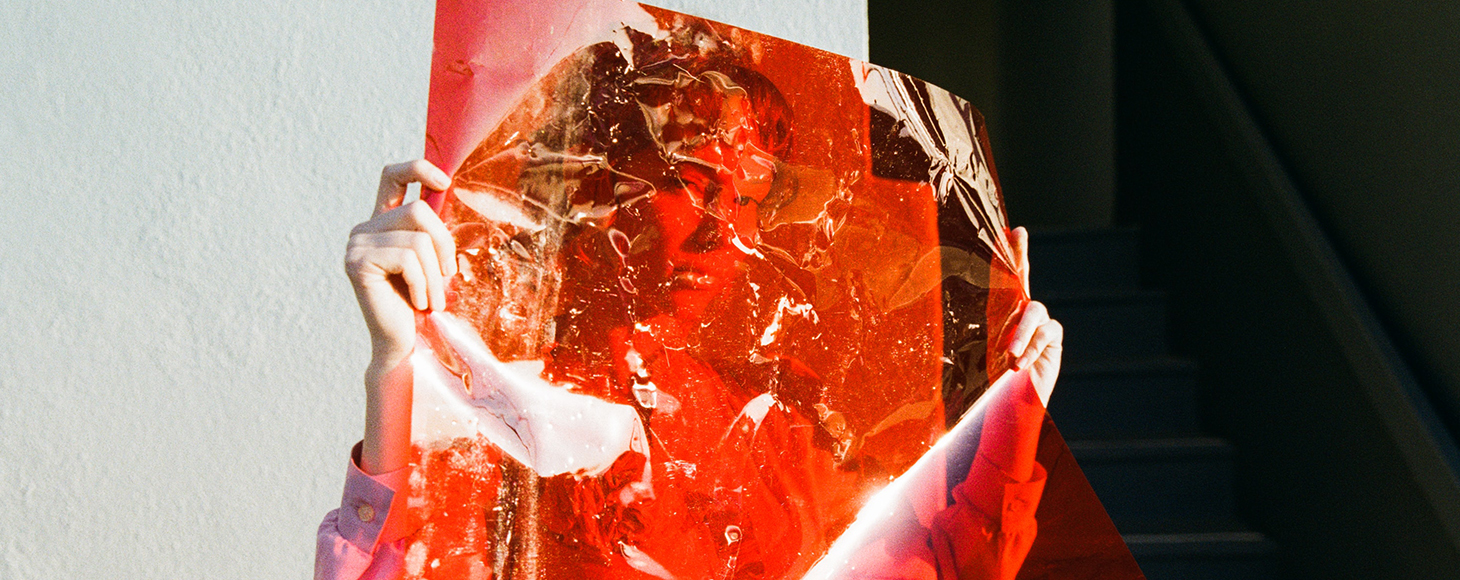 Female hiding behind a transparent red film