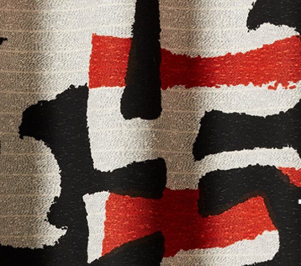A hane-woven fabric by textile weaving compnay named Tibor. The fabic has red, black and off white yarns woven