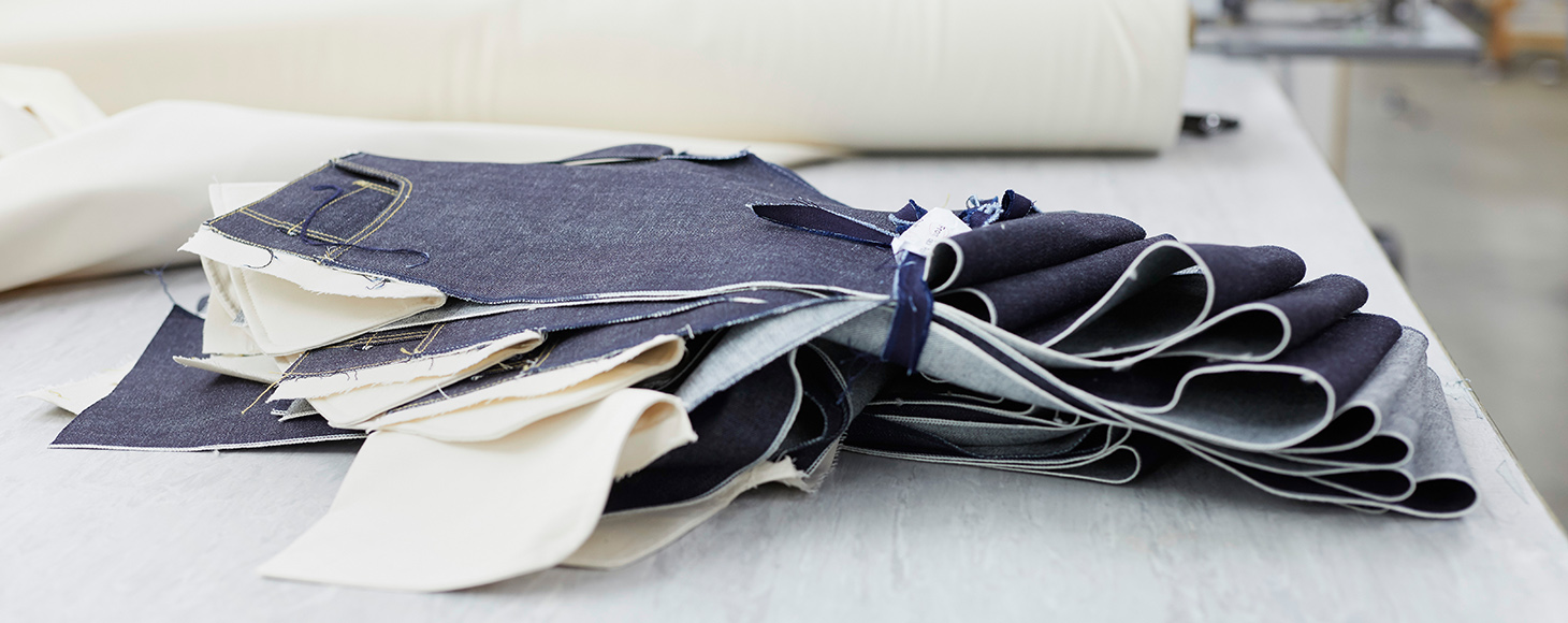 A collection of cut denim to the size is shown on a desk in a studio