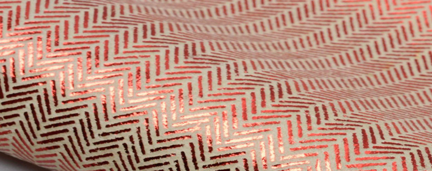 Sample of an un-woven fabric with red print repeat on top