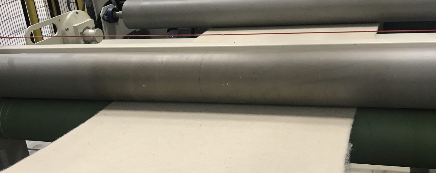 Fabric is being rolled out of a machine
