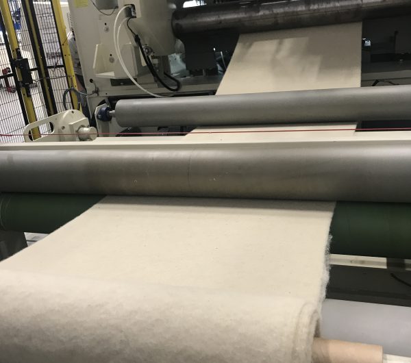 Fabric is being rolled out of a machine